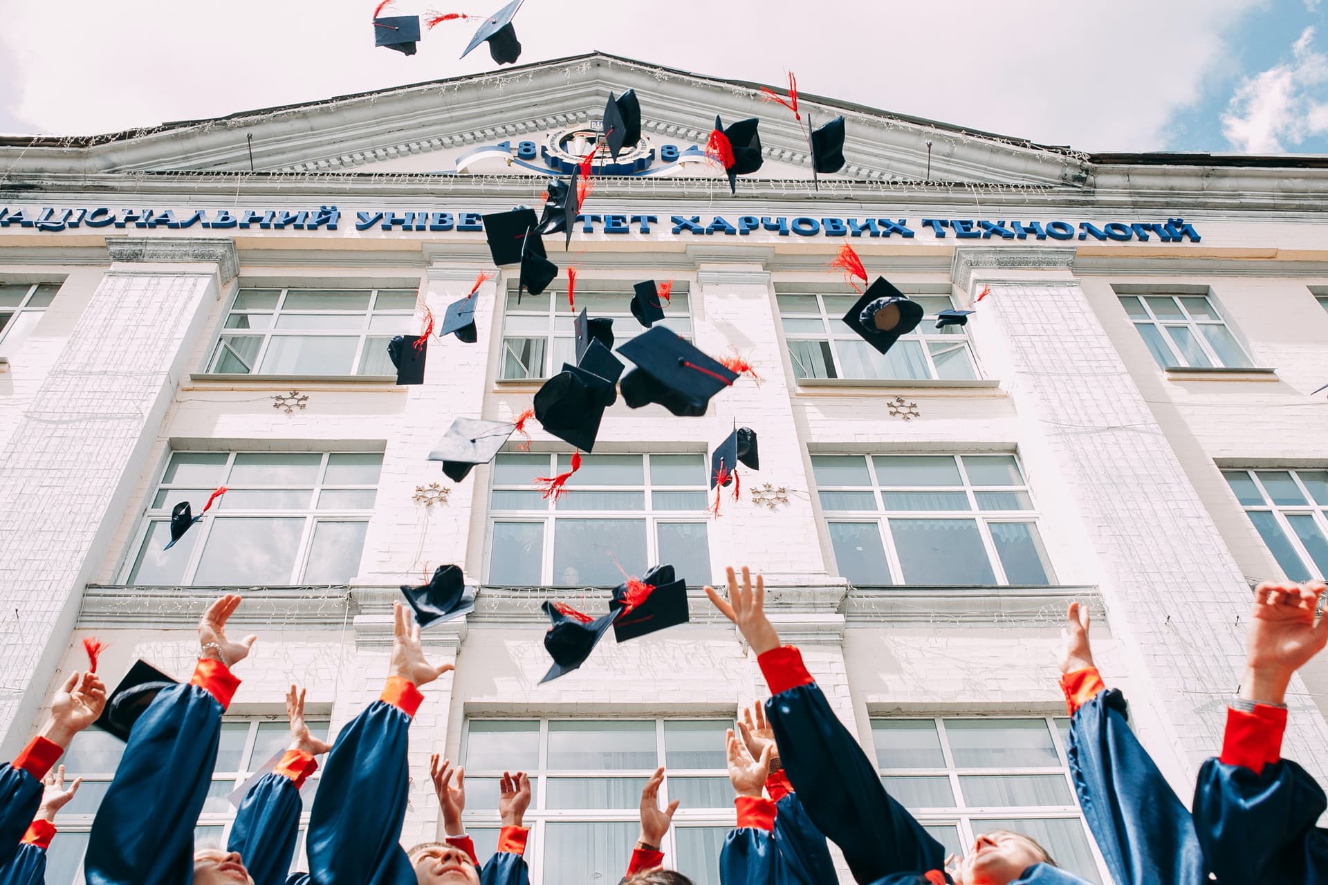 Graduates throwing toga hats in the air