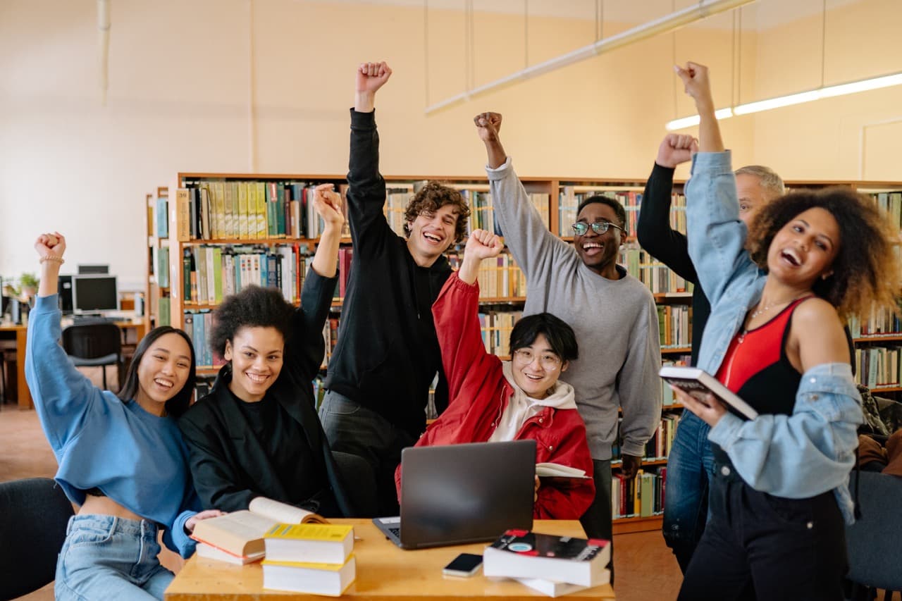 Happy students raising their fists